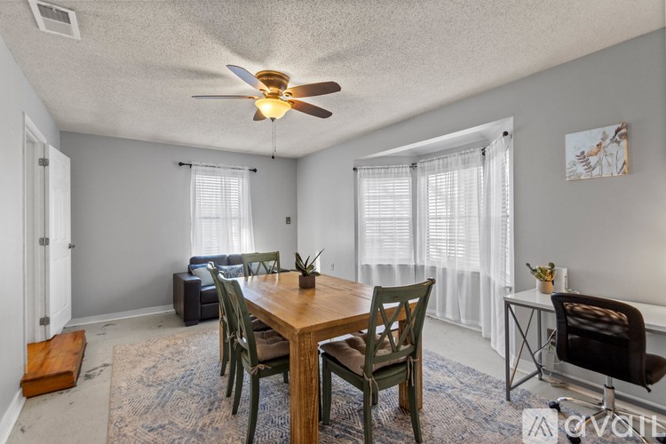 A dining room with a wooden table and chairs.