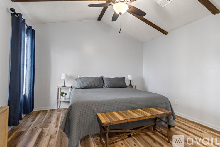 A bedroom with a bed, nightstands, and a ceiling fan.