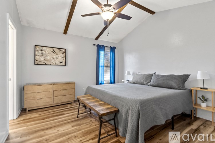 A bedroom with a bed, dresser, and ceiling fan.