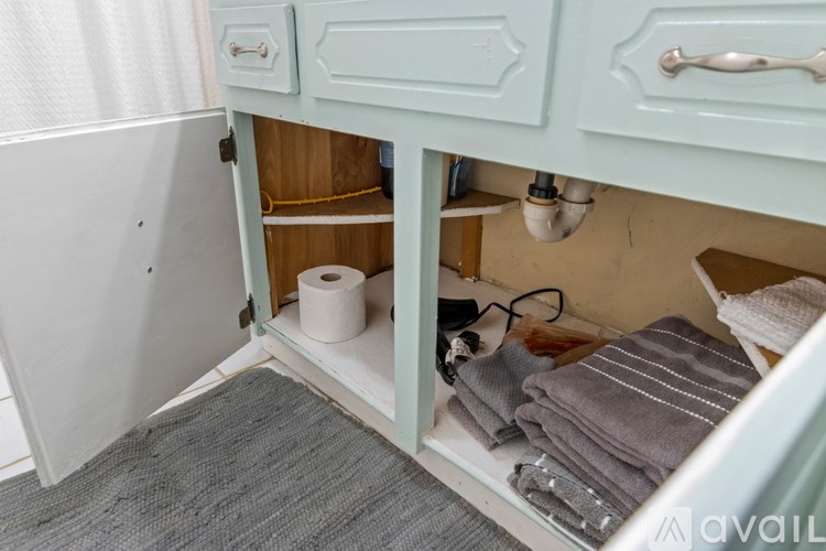 A bathroom with a toilet paper roll and towels.