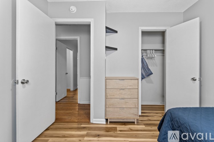 A bedroom with a bed, a wardrobe, and a doorway leading to another room.