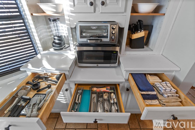 A kitchen with a microwave and oven built into a cabinet.