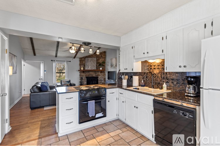 A kitchen with white cabinets and a black oven.