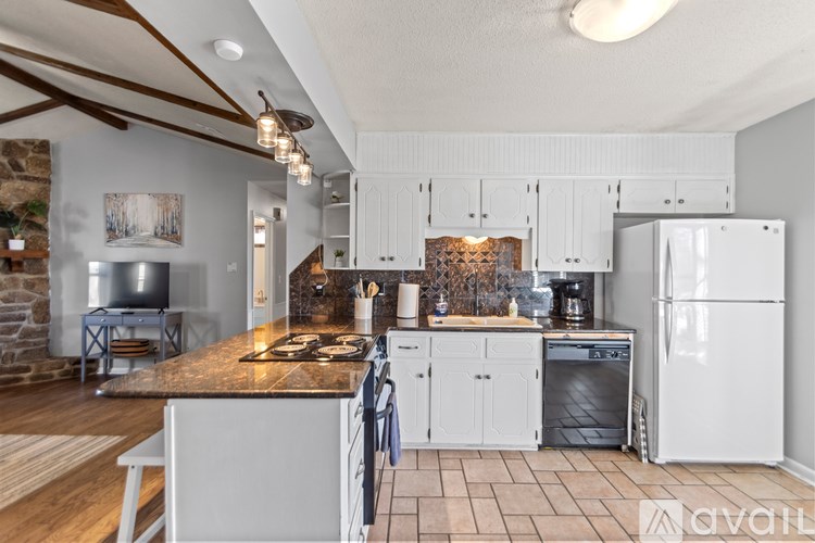 A kitchen with white cabinets and a wooden island.