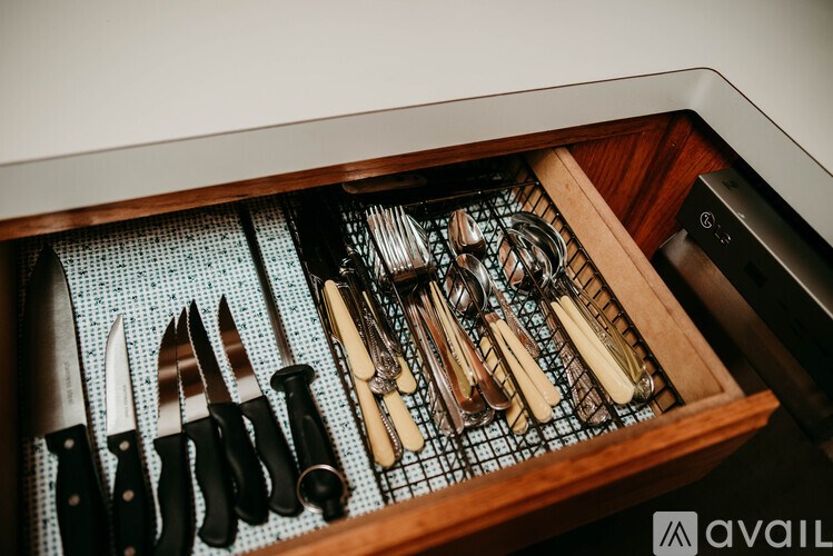 A drawer full of knives and other utensils.