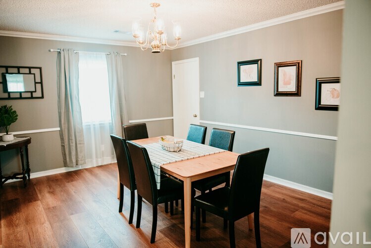 A dining room with a wooden table and chairs.