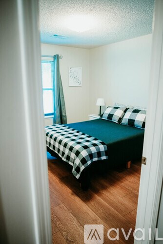 A bedroom with a bed and a window.