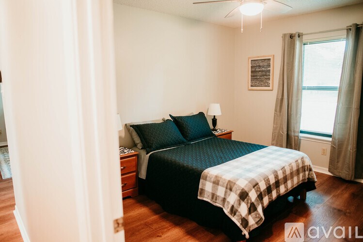 A bedroom with a bed, nightstand, and window.