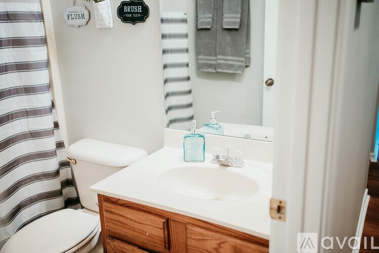 A bathroom with a toilet, sink, and striped shower curtain.