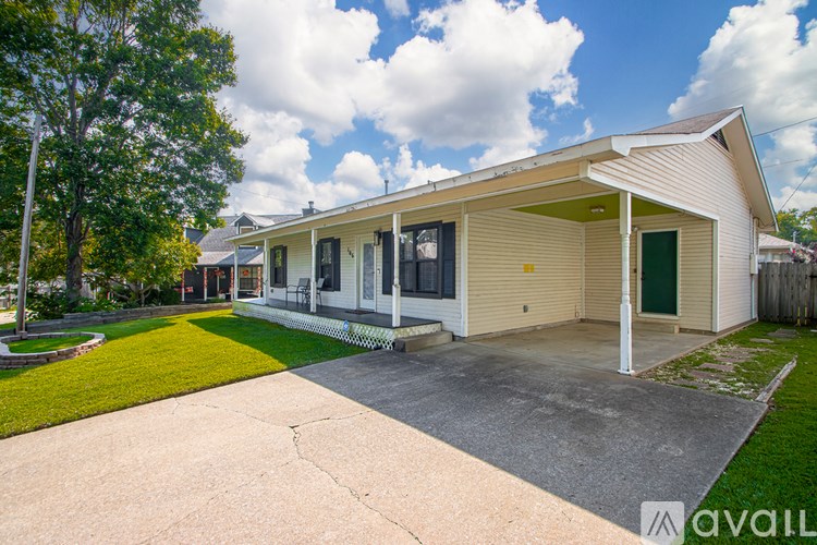 A house with a green door and a driveway in front.