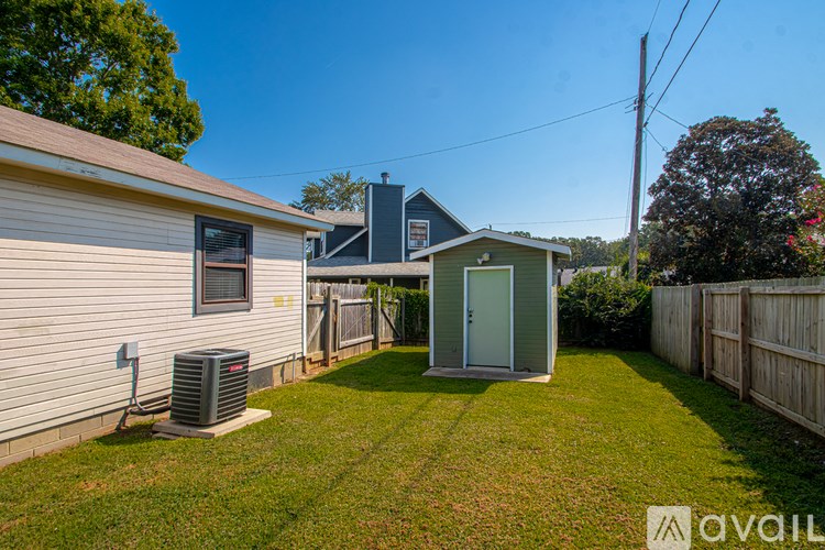 A backyard with a shed and a fence.