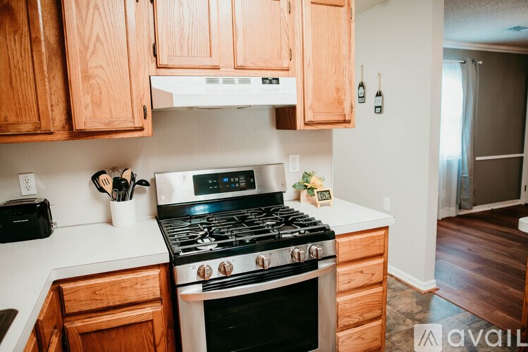 A kitchen with wooden cabinets and a black stove top oven.