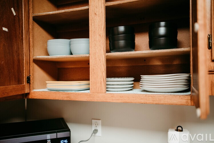 A kitchen cabinet with open shelves holding bowls and plates.