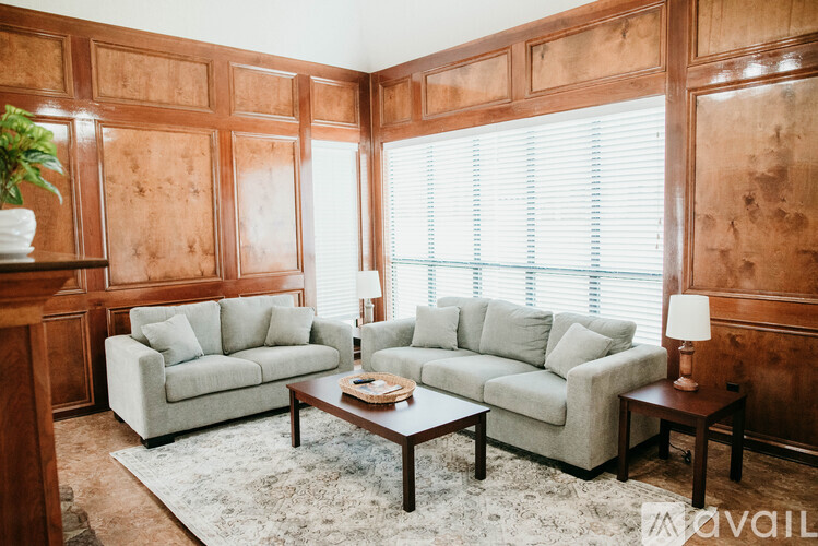 A living room with two couches, a coffee table, and a rug.