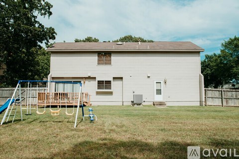 A house with a playground in the front yard.