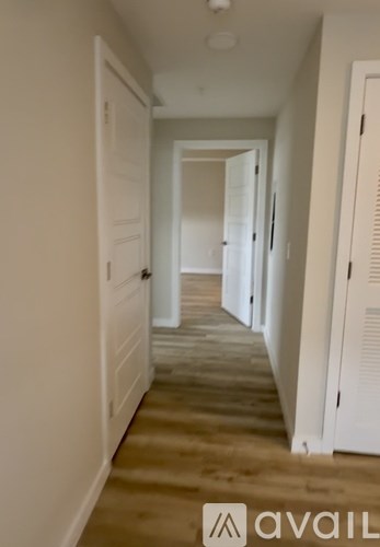 A long hallway with white doors on both sides.