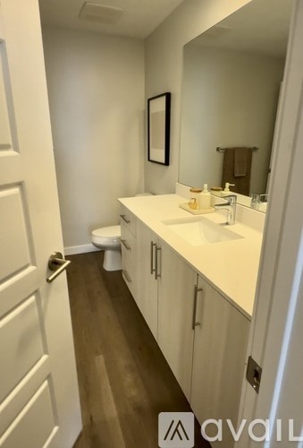 A bathroom with a toilet, sink, and mirror.