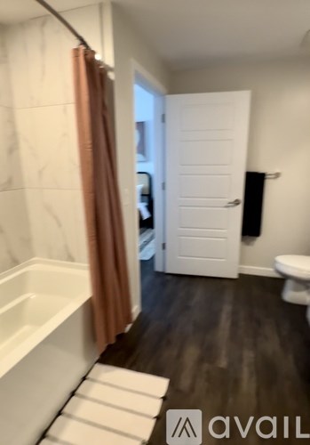 A bathroom with a white tub and a white toilet.