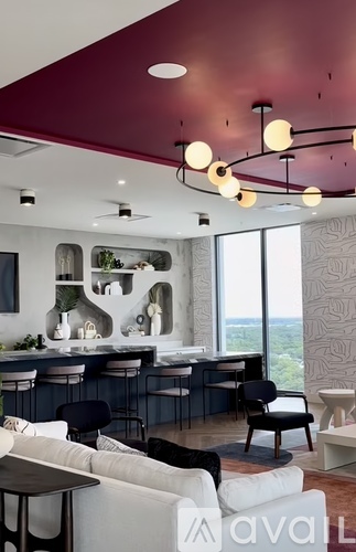 A modern living room with a bar area and a view of the outdoors.