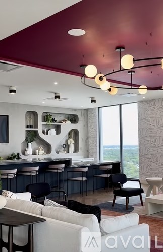 A modern living room with a bar area and a view of the outdoors.