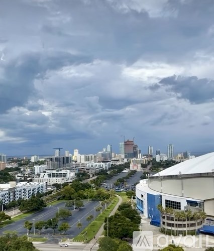 A cityscape with a cloudy sky and a road with cars.
