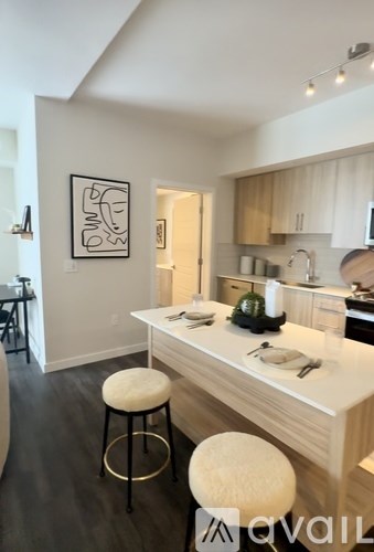 A kitchen with a white counter top and bar stools.