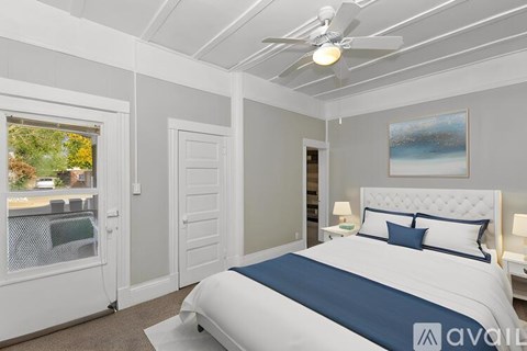 A bedroom with a large bed and a ceiling fan.
