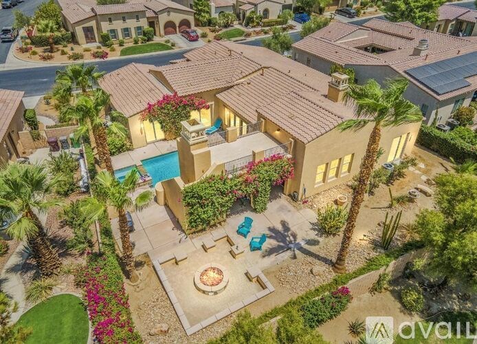 A house with a pool surrounded by palm trees and a patio area.