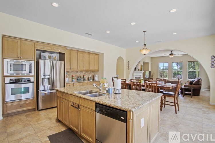 A kitchen with wooden cabinets and a granite countertop.