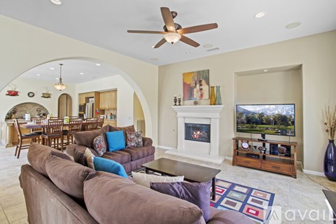 A living room with a brown couch and a fireplace.