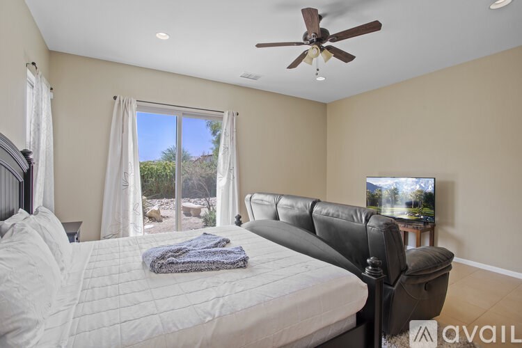 A bedroom with a large bed and a flat screen TV mounted on the wall.