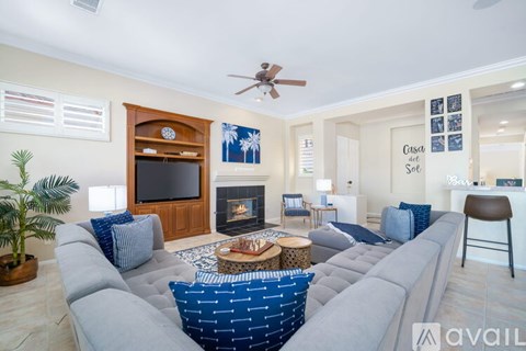 A living room with a grey couch and a wooden entertainment center.
