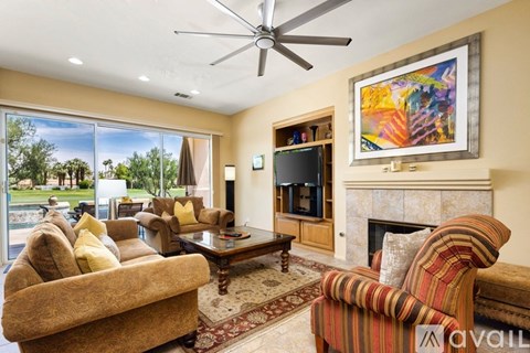 A living room with a fireplace and a painting on the wall.
