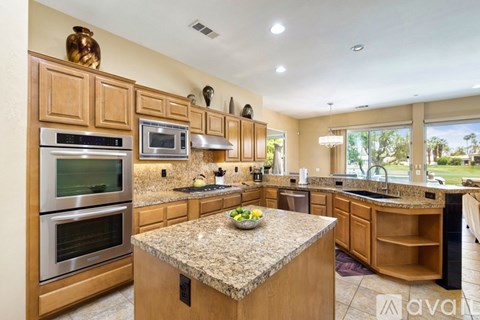 A kitchen with wooden cabinets and granite countertops.