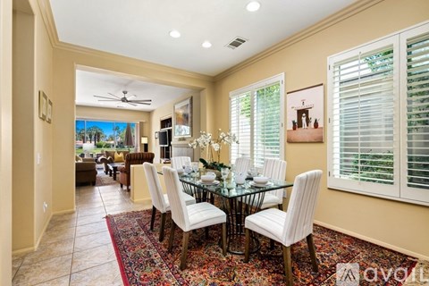 A dining room with a glass table and chairs.