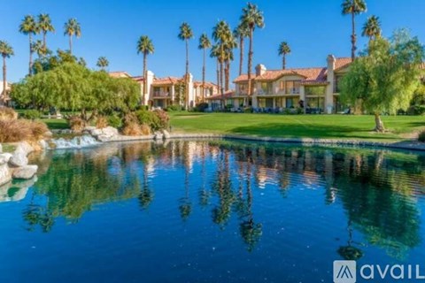 A house with a pool in front of it and palm trees in the background.