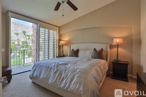 A bedroom with a large bed and a ceiling fan.