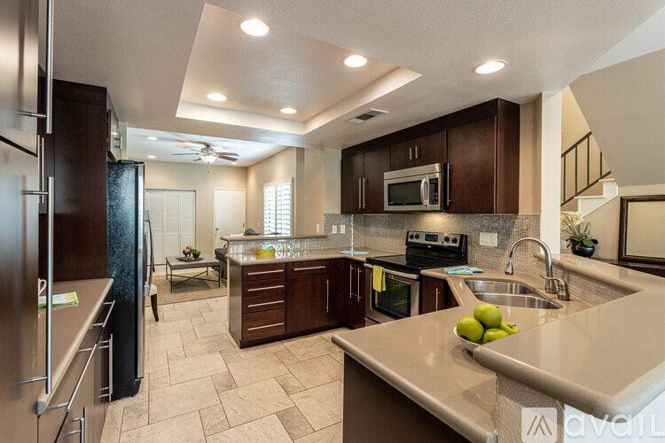 A kitchen with a refrigerator, microwave, oven, sink, and countertop.