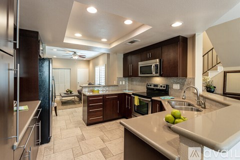 A kitchen with a refrigerator, microwave, oven, sink, and countertop.