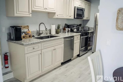 A kitchen with white cabinets and a granite countertop.