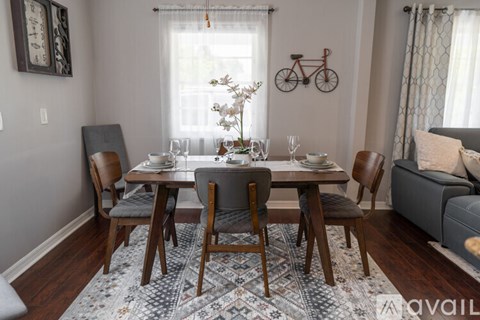 A dining room with a table set for four and a bicycle on the wall.