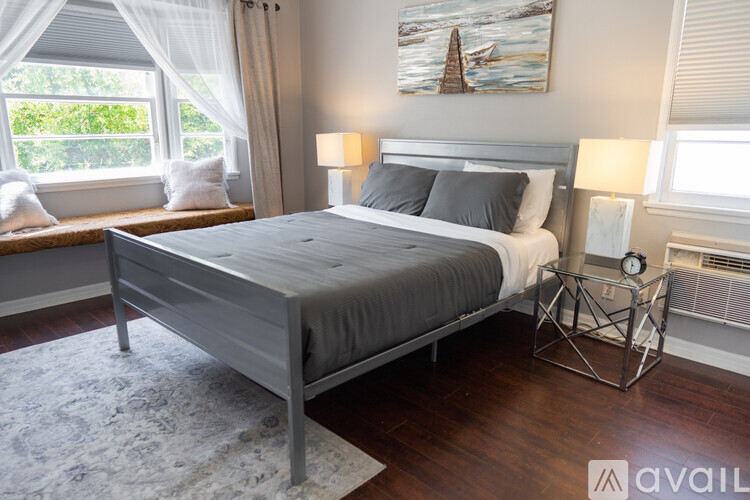 A bedroom with a large bed and a painting on the wall.