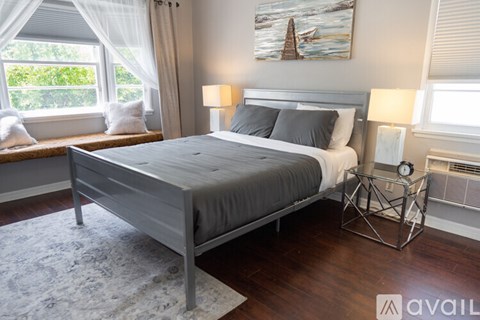 A bedroom with a large bed and a painting on the wall.