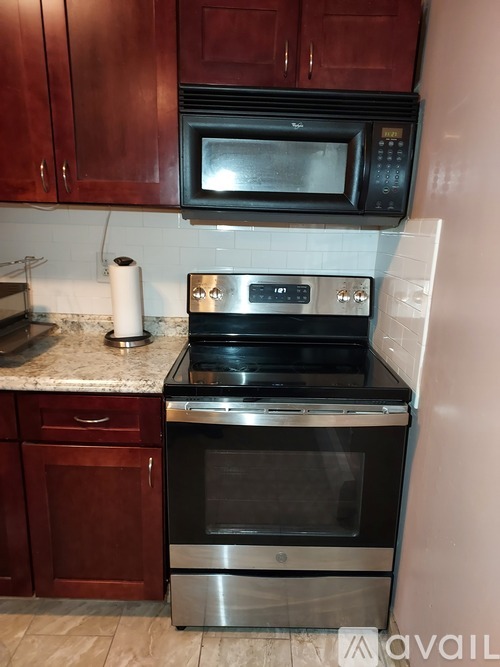 A kitchen with a stainless steel oven and microwave above it.