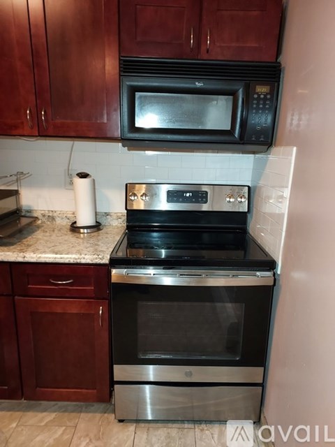 A kitchen with a stainless steel oven and microwave above it.