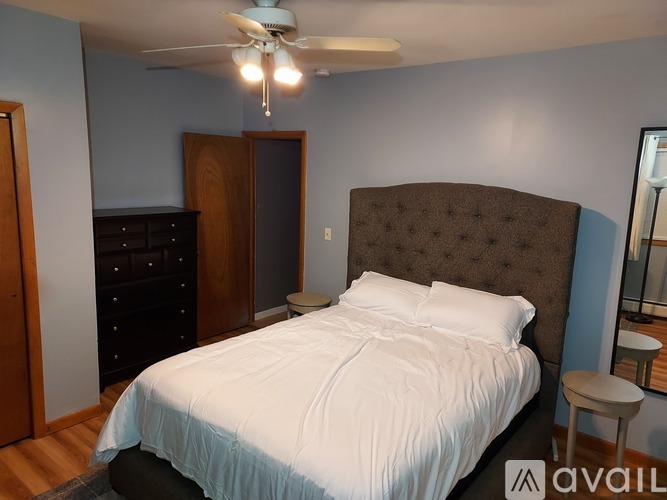 A bedroom with a bed, dresser, and mirror.