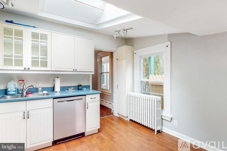 A kitchen with white cabinets and a blue counter.
