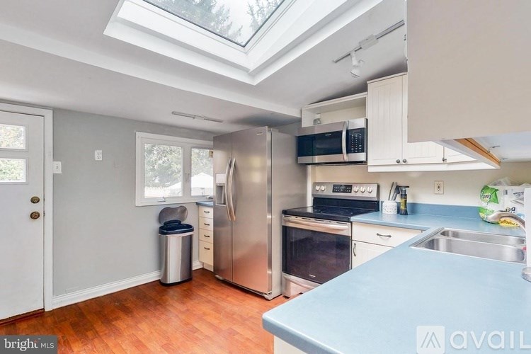 A kitchen with a blue counter top and stainless steel appliances.