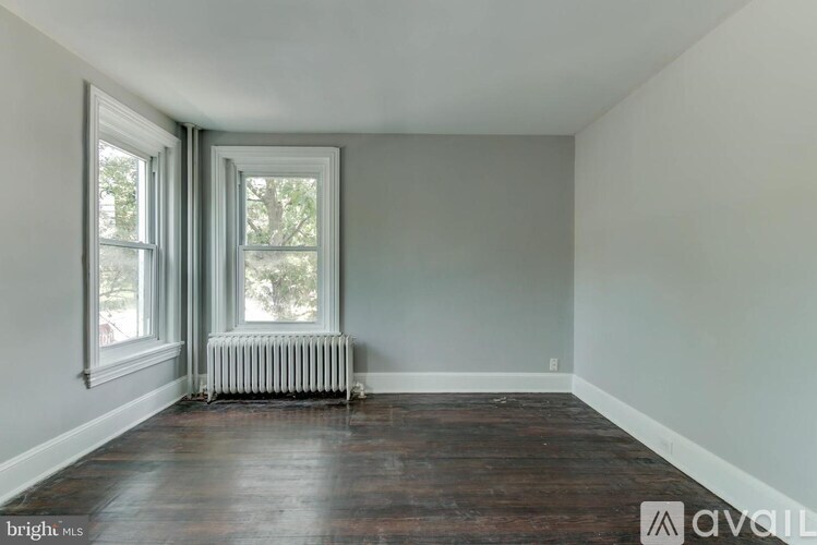 A room with a window and a radiator on the floor.