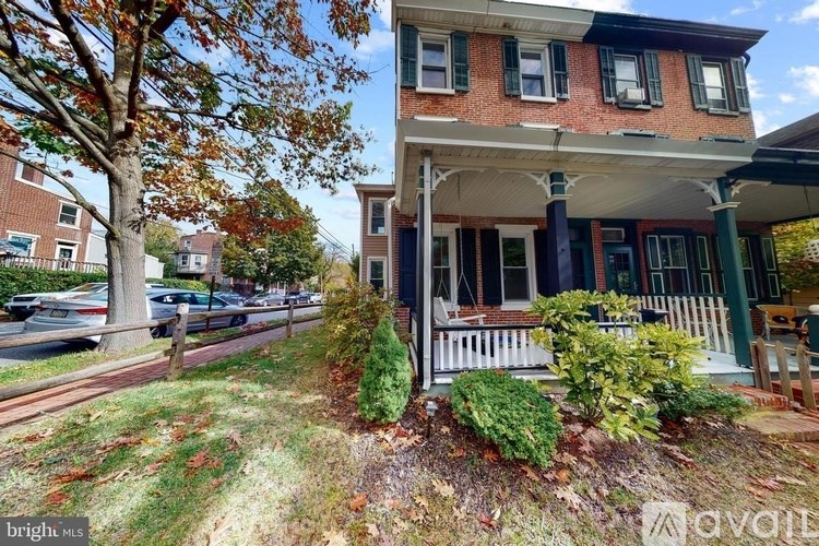 A house with a red brick exterior and a white porch.